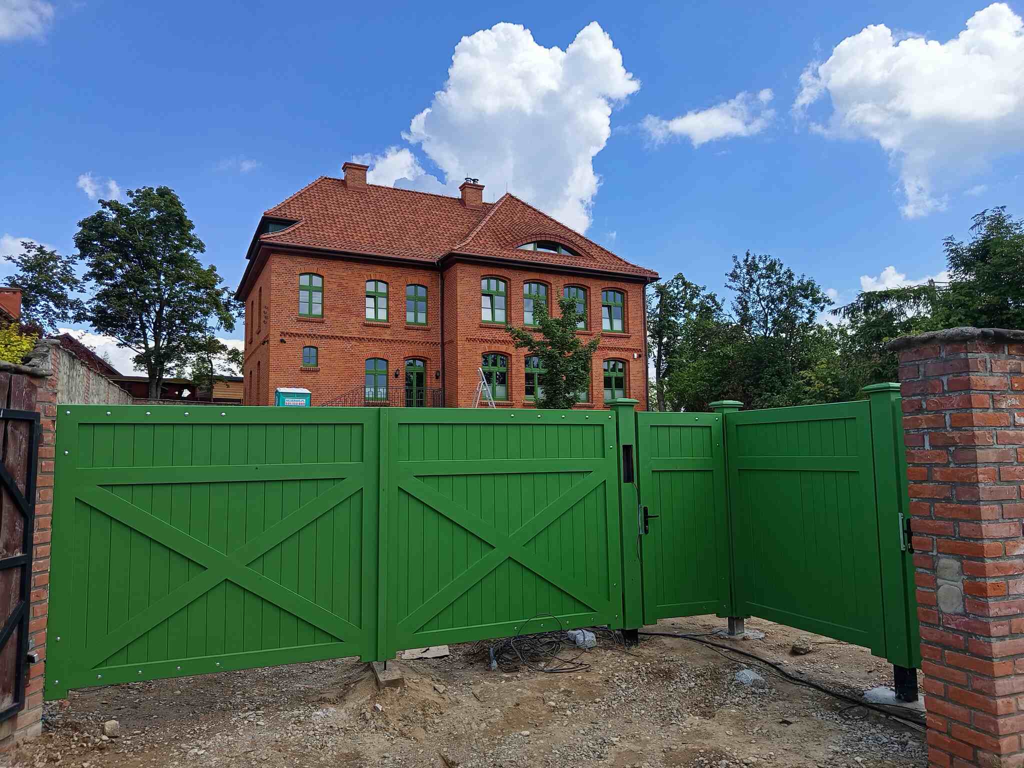 drewniana brama z furtką do starej szkoły na mazurach